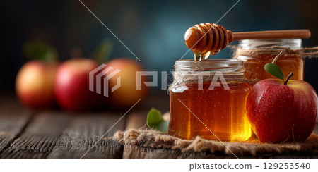 Honey and apples softly glowing on rustic wooden table for Rosh Hashanah 129253540