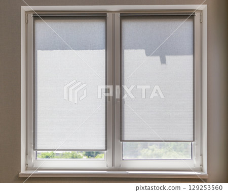 Sun Blocking Gray Roller Shades on Window Sashes Sun Blocking Gray Roller Shades on Window Sashes 129253560