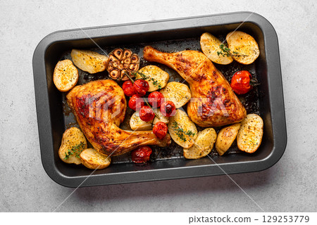 Oven roasted chicken leg quarters with potatoes, tomatoes, garlic and herbs Oven roasted chicken leg quarters with potatoes, tomatoes, garlic and herbs 129253779