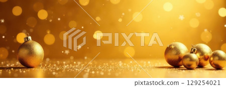 Golden christmas balls decoration on sparkling background with falling snowflakes Golden christmas balls decoration on sparkling background with falling snowflakes 129254021