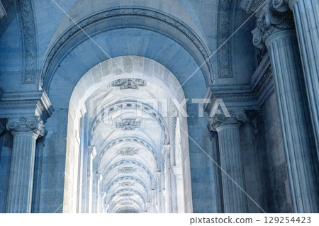 A long hallway features many arches and columns in a major building 129254423