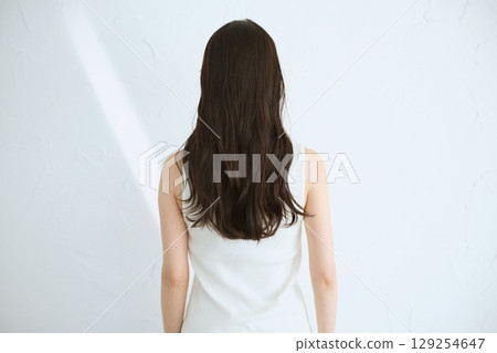 微笑的年輕女子觸摸她的皮膚並進行皮膚護理 - 129254647