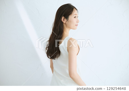 微笑的年輕女子觸摸她的皮膚並進行皮膚護理 - 129254648