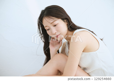 微笑的年輕女子觸摸她的皮膚並進行皮膚護理 - 129254660