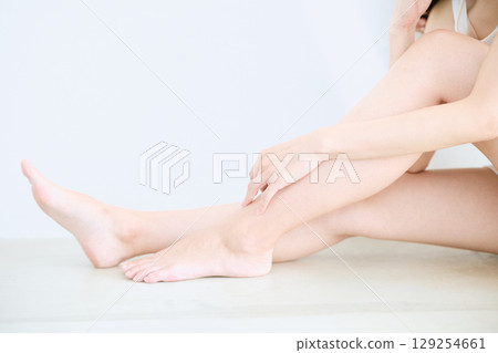 微笑的年輕女子觸摸她的皮膚並進行皮膚護理 - 129254661