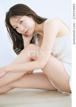微笑的年輕女子觸摸她的皮膚並進行皮膚護理 - 微笑的年輕女子觸摸她的皮膚並進行皮膚護理 - 129254663