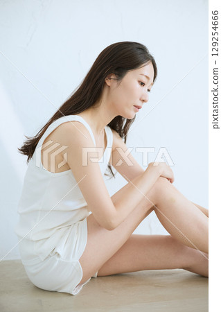 微笑的年輕女子觸摸她的皮膚並進行皮膚護理 - 微笑的年輕女子觸摸她的皮膚並進行皮膚護理 - 129254666
