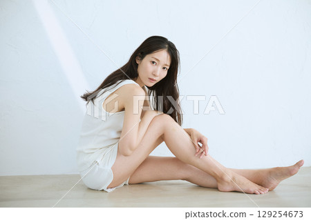 微笑的年輕女子觸摸她的皮膚並進行皮膚護理 - 微笑的年輕女子觸摸她的皮膚並進行皮膚護理 - 129254673