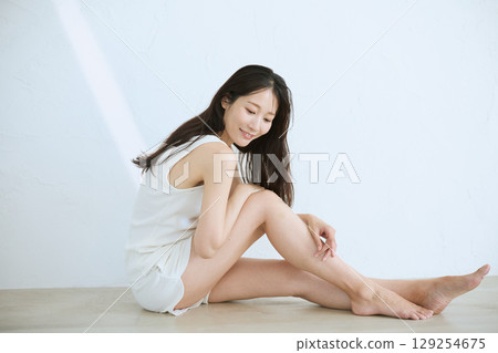 微笑的年輕女子觸摸她的皮膚並進行皮膚護理 - 微笑的年輕女子觸摸她的皮膚並進行皮膚護理 - 129254675