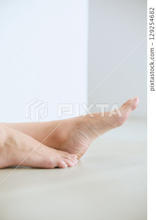 Smiling young woman touching her skin and doing skin care - 129254682