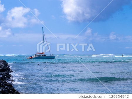 A relaxing yacht holiday scene on a clear tropical sea 129254942