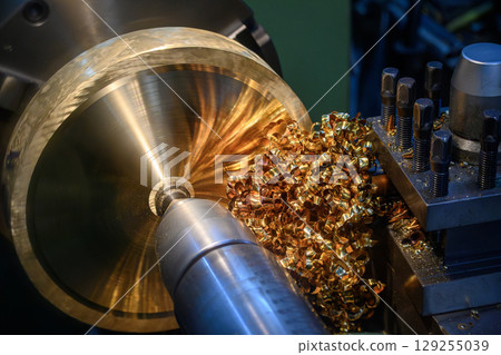 Close up scene the lathe machine finish cut the brass material parts and the pile of scrap chips. 129255039