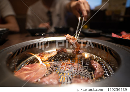 Hands of a man grilling yakiniku 129256589