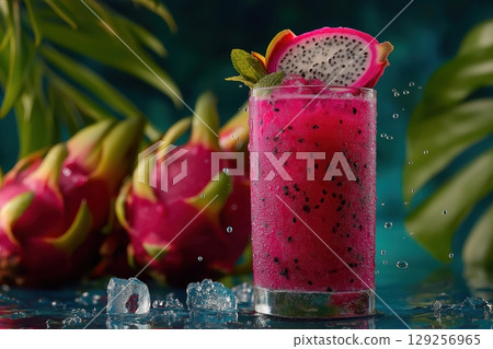 Bright dragonfruit daiquiri with fruit garnish on reflective surface and leaves 129256965