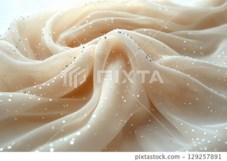 Expensive fabric. Soft studio light. Bridal tulle fabric with crystal embellishments on a white background. 129257891