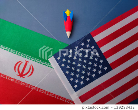 Top view rocket between us america and iran flag on a blue background. Geopoilitic concept.. 129258432