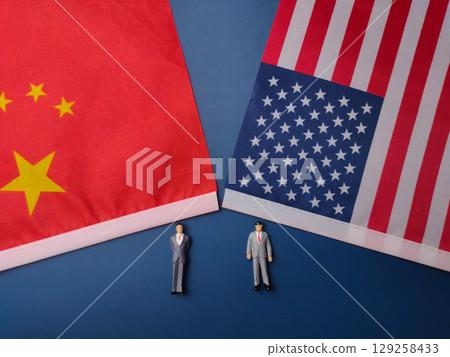 China and us america flag with miniature people on a blue background. China and us america flag with miniature people on a blue background. 129258433
