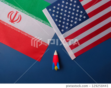 Top view rocket between us america and iran flag on a blue background. Geopoilitic concept. 129258441