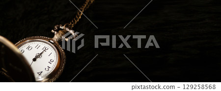 A classic old and retro watch with the twelve o'clock hour marked, set against a clean black background. This image is perfect for a New Year banner or countdown, with ample copy space A classic old and retro watch with the twelve o'clock hour marked, set against a clean black background. This image is perfect for a New Year banner or countdown, with ample copy space 129258568