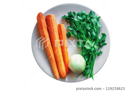 Fresh vegetables on ceramic plate isolated on white background. Peeled carrots, onions, green parsley top view Fresh vegetables on ceramic plate isolated on white background. Peeled carrots, onions, green parsley top view 129258625