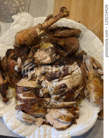 Carved roasted turkey for the calebration Thanksgiving or Christmas dinner on a plate 129259426