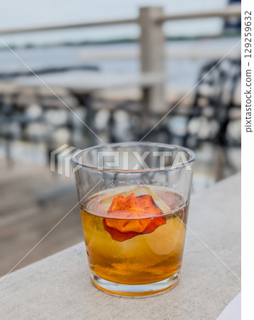 old fashion whiskey drink with persimmon on table old fashion whiskey drink with persimmon on table 129259632