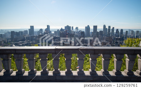 Scenic view of Montreal's skyline showcasing its diverse architecture, with lush green trees in the foreground and the St. Lawrence River in background. Scenic view of Montreal's skyline showcasing its diverse architecture, with lush green trees in the foreground and the St. Lawrence River in background. 129259761