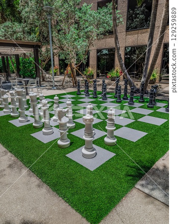 Closeup image of giant chessboard and chess figures in park. 129259889