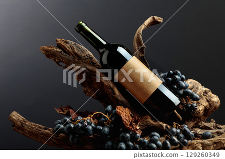 Bottle of red wine with empty label on a old snags. 129260349