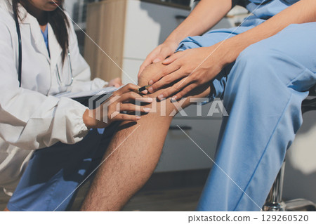 Physical therapist teaching a patient how to do exercises for his knee pain Physical therapist teaching a patient how to do exercises for his knee pain 129260520