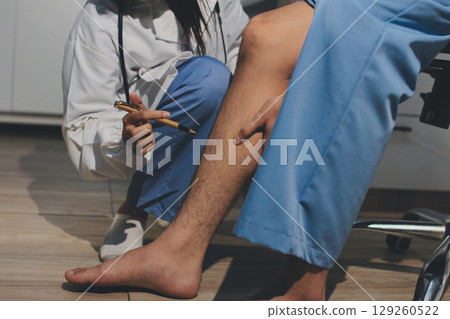 Physical therapist teaching a patient how to do exercises for his knee pain Physical therapist teaching a patient how to do exercises for his knee pain 129260522