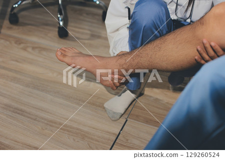 Physical therapist teaching a patient how to do exercises for his knee pain Physical therapist teaching a patient how to do exercises for his knee pain 129260524