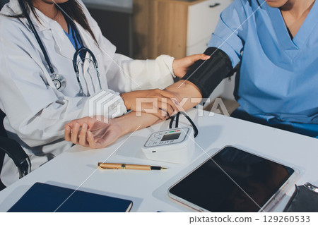 Doctor checking patient arterial blood pressure in hospital. Health care Concept 129260533