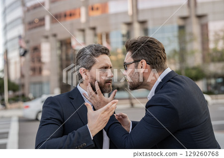 Angry businessmen. Business conflict. Two businessmen conflicting at fight outdoor. Businessmen having conflict in business. Conflict between boss and employee. Fight aggression. Blaming each other 129260768