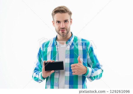 man shows phone screen in studio, thumb up. man showing phone screen on background man shows phone screen in studio, thumb up. man showing phone screen on background 129261096