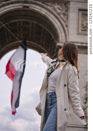 Back view of woman waving French flag in Paris  129261218