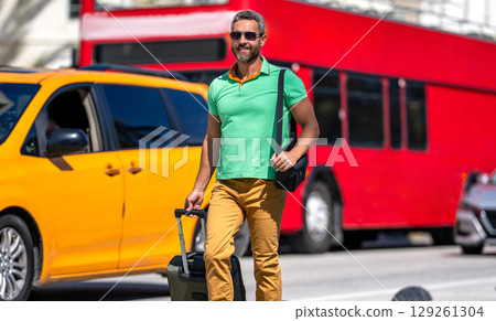 Man 40s tourist on summer vacation. Traveler trip luggage. Summer tour. Traveler enjoy summer trip. Hispanic tourist traveler walking on street. Tourist with suitcase in tropical city, destination Man 40s tourist on summer vacation. Traveler trip luggage. Summer tour. Traveler enjoy summer trip. Hispanic tourist traveler walking on street. Tourist with suitcase in tropical city, destination 129261304