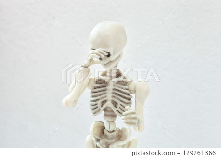 Human skeleton covers his face with his hand, shy and shame concept 129261366
