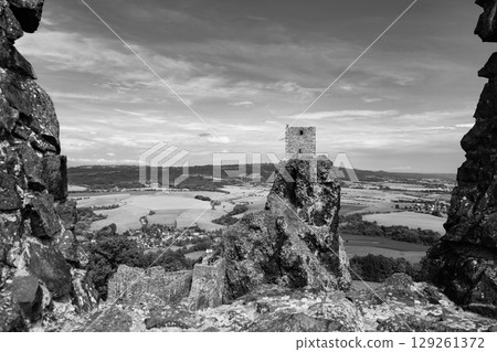 Panna Tower stands atop a rocky outcrop within the Trosky Castle ruins, offering a panoramic view of the lush countryside and valleys of Bohemian Paradise during a clear day. 129261372