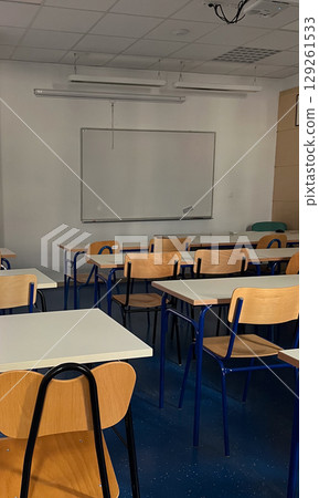 Vertical empty classroom with high-tech whiteboards and ergonomic chairs. Vertical empty classroom with high-tech whiteboards and ergonomic chairs. 129261533