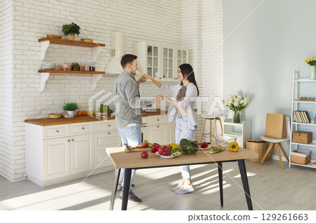 Happy Family Couple Dancing Together In The Kitchen While Cooking Food At Home Happy Family Couple Dancing Together In The Kitchen While Cooking Food At Home 129261663