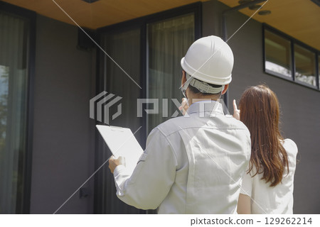 A builder and a woman discussing a house 129262214