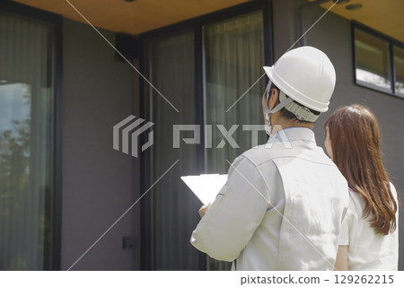 A builder and a woman discussing a house A builder and a woman discussing a house 129262215