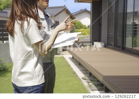 A builder and a woman discussing a house 129262217