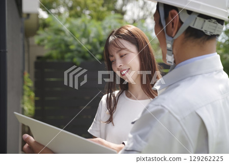A builder and a woman discussing a house A builder and a woman discussing a house 129262225