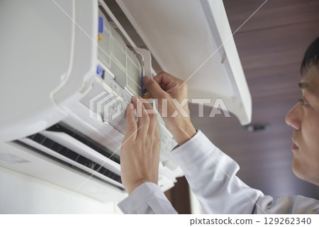 Hands of a male worker inspecting an air conditioner Hands of a male worker inspecting an air conditioner 129262340