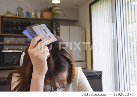A woman having trouble paying her credit card bill 129262375