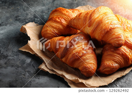 Freshly Baked Croissants on Rustic Paper with Golden Brown Layers and Flaky Texture Freshly Baked Croissants on Rustic Paper with Golden Brown Layers and Flaky Texture 129262492