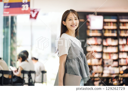 站在圖書館裡微笑的年輕女子 129262729