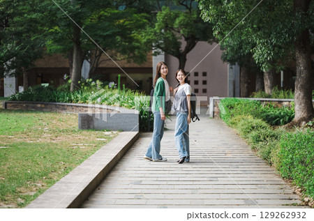 Portrait of a young woman walking in the park with friends 129262932